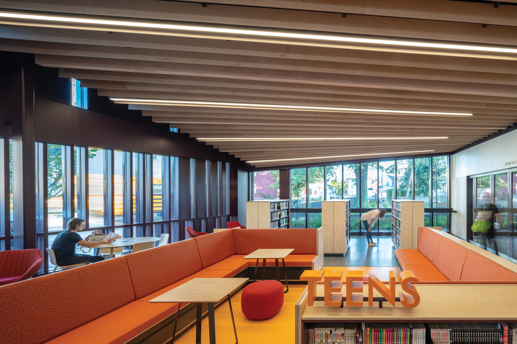 Teen wing interior with the TEENS sign and full-height windows looking out to Adams Street