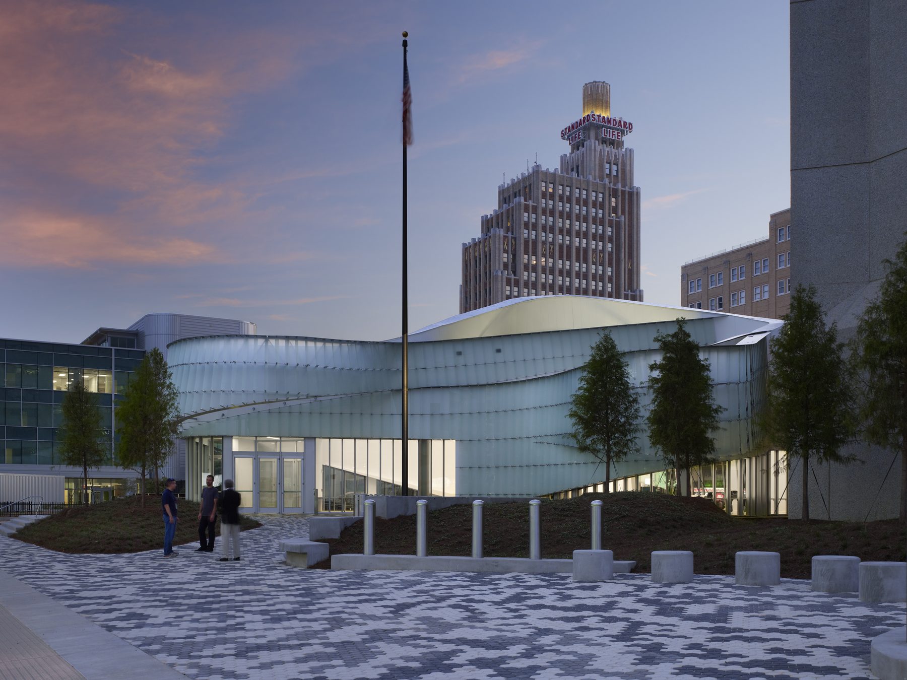 The pavilion at dusk, with the Standard Life tower rising behind and a flagpole on the entry plaza